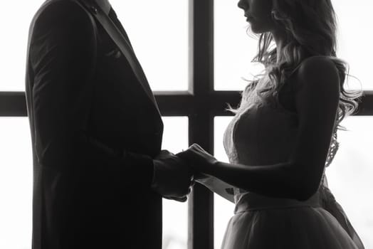 Beautiful wedding couple. Luxurious dress of the bride and stylish suit of the groom.