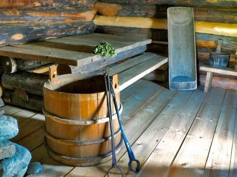 The interior of a wooden house, benches, bucket and shelves of wood The interior of a wooden house, benches, bucket and shelves of wood