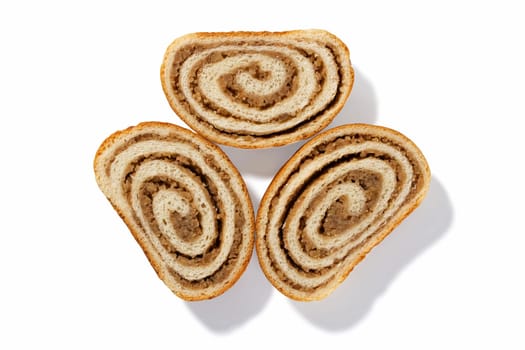 Indulge in the rich flavors of three slices of German nut bread, each adorned with crunchy walnuts and a golden-brown crust, set against a clean white backdrop
