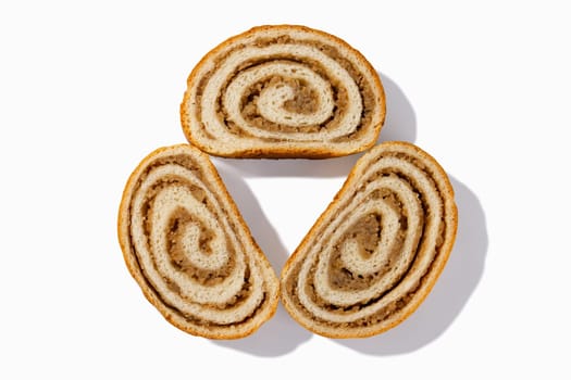 Enjoy three slices of German nut bread, each boasting crunchy walnuts and a golden-brown crust, set against a pristine white backdrop