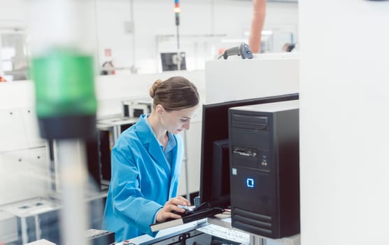woman electrical engineer working on a placement line in a factory manufacturing electronics.