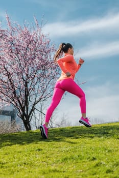 Woman running on hill for fitness as a sport in front of city