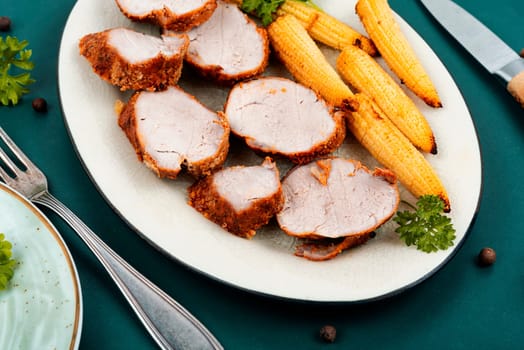 Sliced pork tenderloin grilled with corn. Baked meat