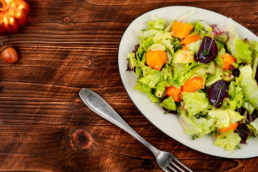 Healthy vegan cuisine, autumn salad of baked pumpkin, beetroot and greens. Vegan food. Top view.
