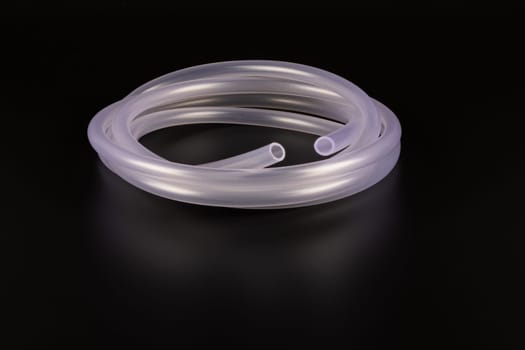 transparent plastic tube coil on black background.