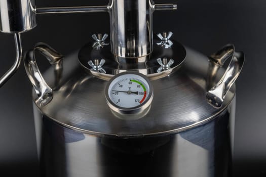 brand new stainless steel alcohol machine or moonshine still on black background.