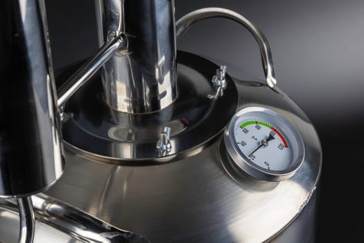 brand new stainless steel alcohol machine or moonshine still on black background.