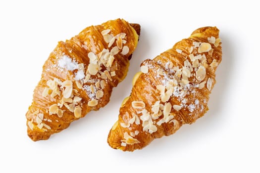 Enjoy the indulgence of two croissants filled with aromatic vanilla cream, topped with crunchy almond flakes, set against a clean white backdrop
