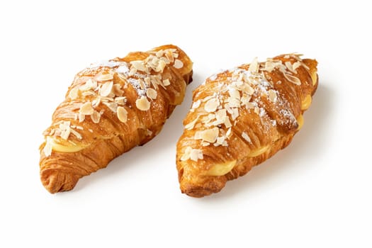 Dive into the delightful pairing of two croissants filled with aromatic vanilla cream and adorned with crunchy almond flakes, presented against a pristine white backdrop