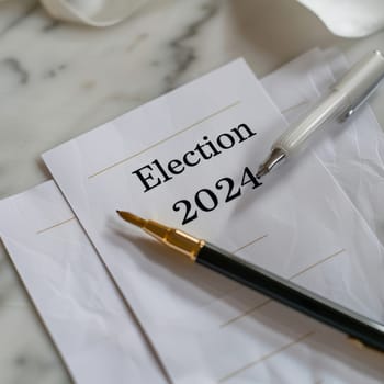 A piece of paper with the word Election written in black ink and a blue pen resting beside it