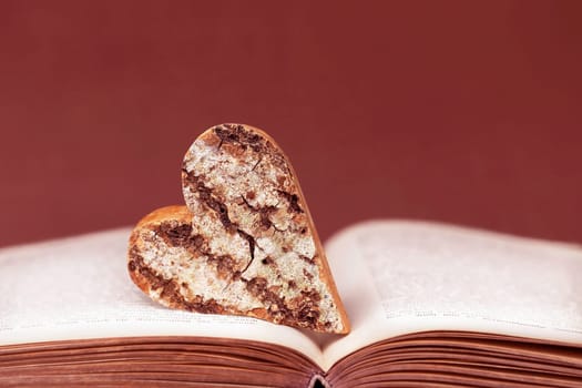 A wooden heart with bark on an old book