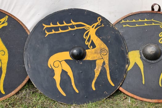Medieval weapons, shields in knight camp at the festival of historical reconstruction