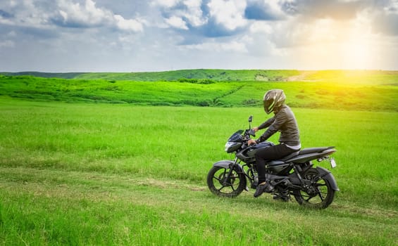 Biker man on a country road, young man on his motorcycle traveling through the countryside with copy space, man riding motorcycle in the countryside
