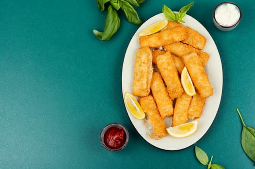 Fish fingers or nuggets, crispy fish steak on the plate. Fish sticks.
