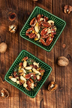 Large assortment of peeled nuts in bowl on a vintage wooden background. Superfood.