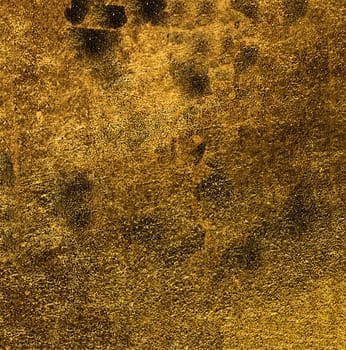 Rough uneven golden surface with dark spots