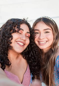 Close up of two cute girls taking a selfie, smiling girls taking a self portrait, Selfie of two girls