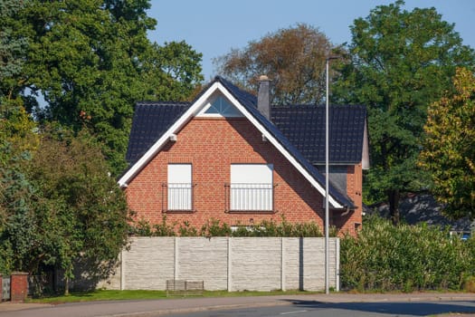 Brick house with garden fence in the countryside, Rekum, Bremen, Germany