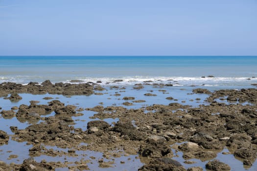 Sea rock reef with blue sky