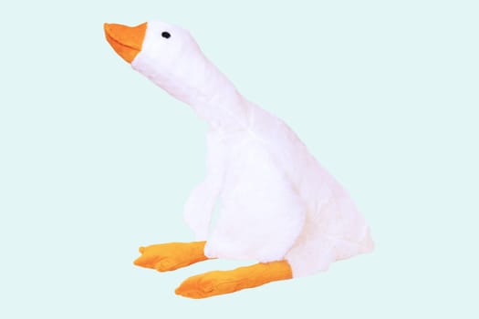 Childrens toy stuffed animals. Soft white plush toy duck for kids isolated on a light blue background. Duck teddy toy. White duck for playing.