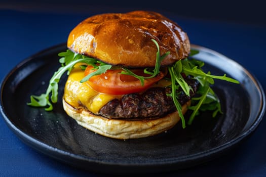 A gourmet burger rests on a black plate, enticing with its juicy patty, fresh lettuce, and melted cheese.