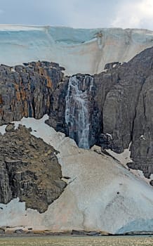 Massive Waterfall From a Melting Coastal Glacier at Alkefjellet in the Svalbard Islands