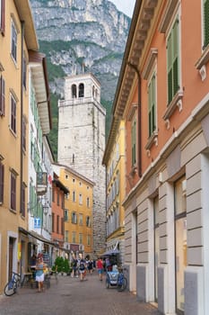Narrow alley with tourists in the popular historic old town of Riva del Garda on Lake Garda in Italy
