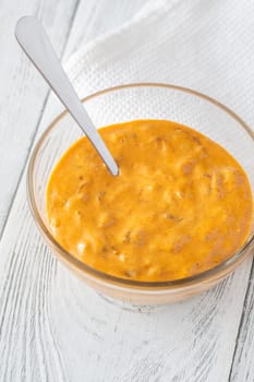 Glass bowl of burger sauce on the wooden table
