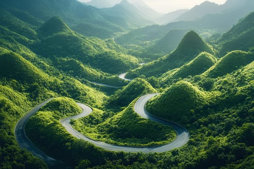 A beautiful summer view from above of a serpentine road among the green hills. The concept of traveling by car.