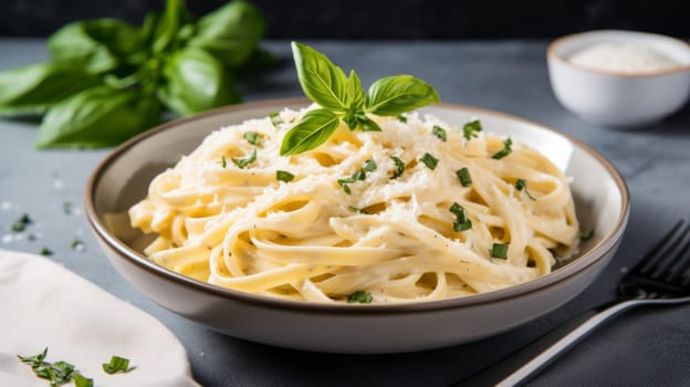 A bowl of creamy pasta with grated parmesan cheese and fresh basil