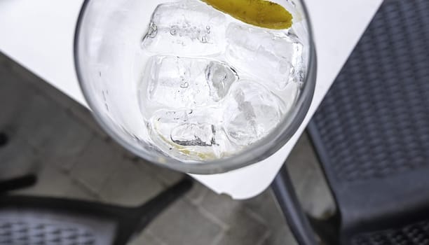Detail of glass cup with ice, alcoholic drink, soft drink and party
