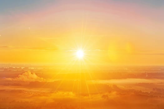 The sun is lowering in the sky, casting a warm light over the clouds. The clouds are billowing and reflecting the orange hues of the setting sun.