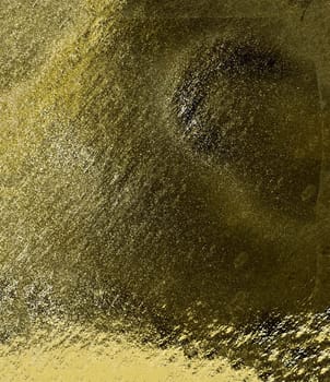 Rough abstract golden textured background with bulges and irregularities in close-up
