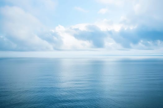 A vast expanse of water stretches out under a sky filled with thick clouds, creating a moody and dramatic atmosphere. The water reflects the overcast sky, with ripples indicating a slight breeze on the surface.