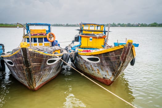 Traditional fishing boats moored on Thu Bon River in the town of Hoi An, Vietnam
