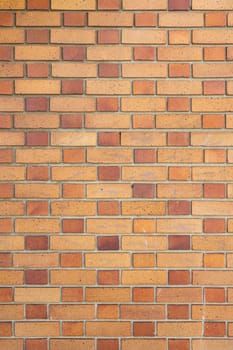 High resolution texture, pattern of yellow and brown brick wall structure as background. Brick masonry horizontal color technology architecture wallpaper. Vertical photo, close-up.