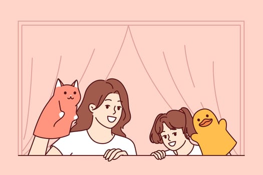 Home puppet theater from mother and daughter for family members or classmates of girl. Happy woman helps schoolgirl set up puppet theater and encourages child creative development.