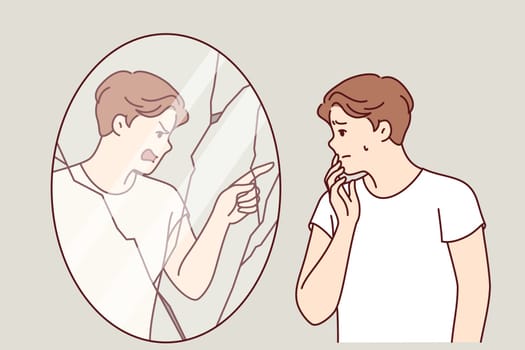 Man suffering from hallucinations and mental disorder looks in mirror with evil reflection blaming owner. Guy with low self-esteem experiences fear due to hallucinations or split personality