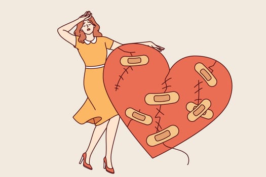 Woman cries after breaking up with man and having problematic relationship, standing near large wounded heart. Upset girl is stressed because of unrequited love or tactical relationship with husband