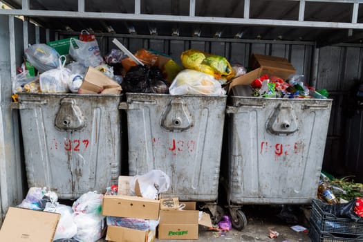 overfilled public trash bins at summer day in Bishkek, Kyrgyzstan - May 24, 2023