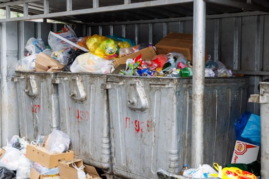 overfilled public trash bins at summer day in Bishkek, Kyrgyzstan - May 24, 2023