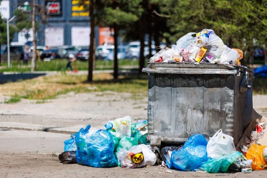 overfilled public trash bins at summer day in Bishkek, Kyrgyzstan - May 26, 2023
