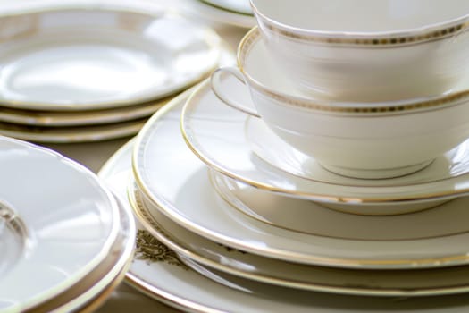A neat stack of white and gold china plates is showcased in this image. The plates are arranged uniformly, showcasing their elegant design and color contrast.