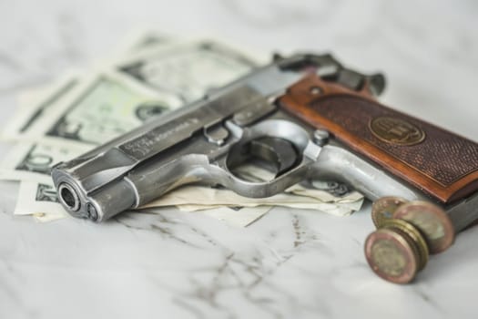 A gun is placed on a stack of money, symbolizing power, wealth, and potential danger. The juxtaposition of these two items creates a tense and thought-provoking scene.
