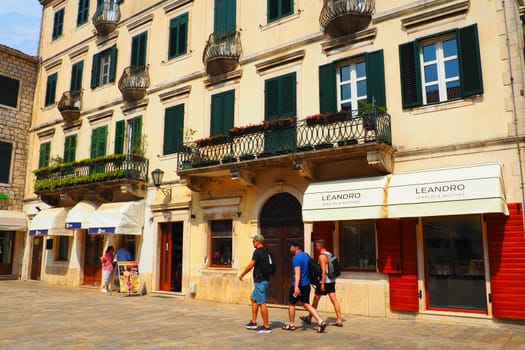 Kotor, Montenegro, 08.11.22: Trg od Oruzja, Arms Square, town square in old city. Square of the Arms. Tourists, women and men, walk along paving stones. Restaurants, souvenir shops. Excursion tourism