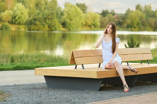 Young woman calling to her friend while resting in public park