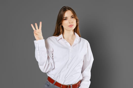 Smart woman shows three fingers. Counting with fingers concept.