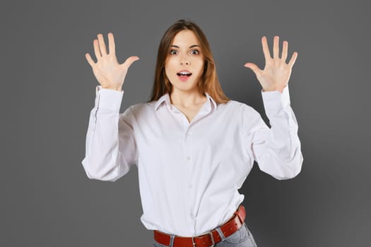 Surprised young woman shows ten fingers. Counting with fingers concept.