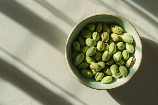 A bowl overflowing with pistachios sits elegantly on a white surface, inviting indulgence.