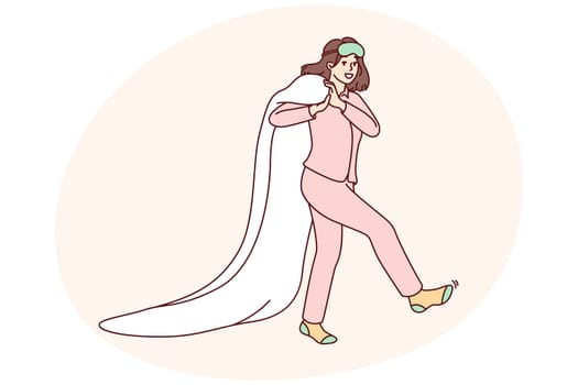Happy woman in pajamas and socks after morning awakening walks dragging blanket behind back. Young caucasian girl in good mood goes to bed to rest after hard day work